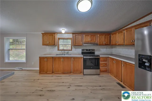 a kitchen with stainless steel appliances granite countertop a stove a sink and a refrigerator