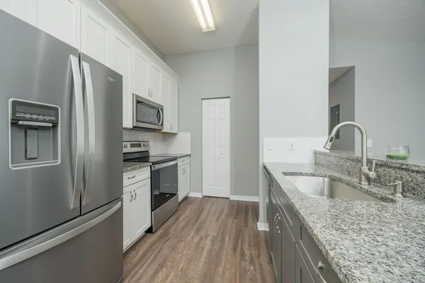 a kitchen with stainless steel appliances granite countertop a sink stove and refrigerator