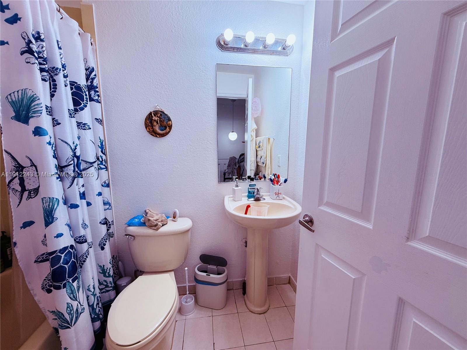 2243 Northwest 135th Terrace, Unit 2243 Opa-Locka, FL 33054 - Photo 17 of 19 a bathroom with a sink toilet and mirror