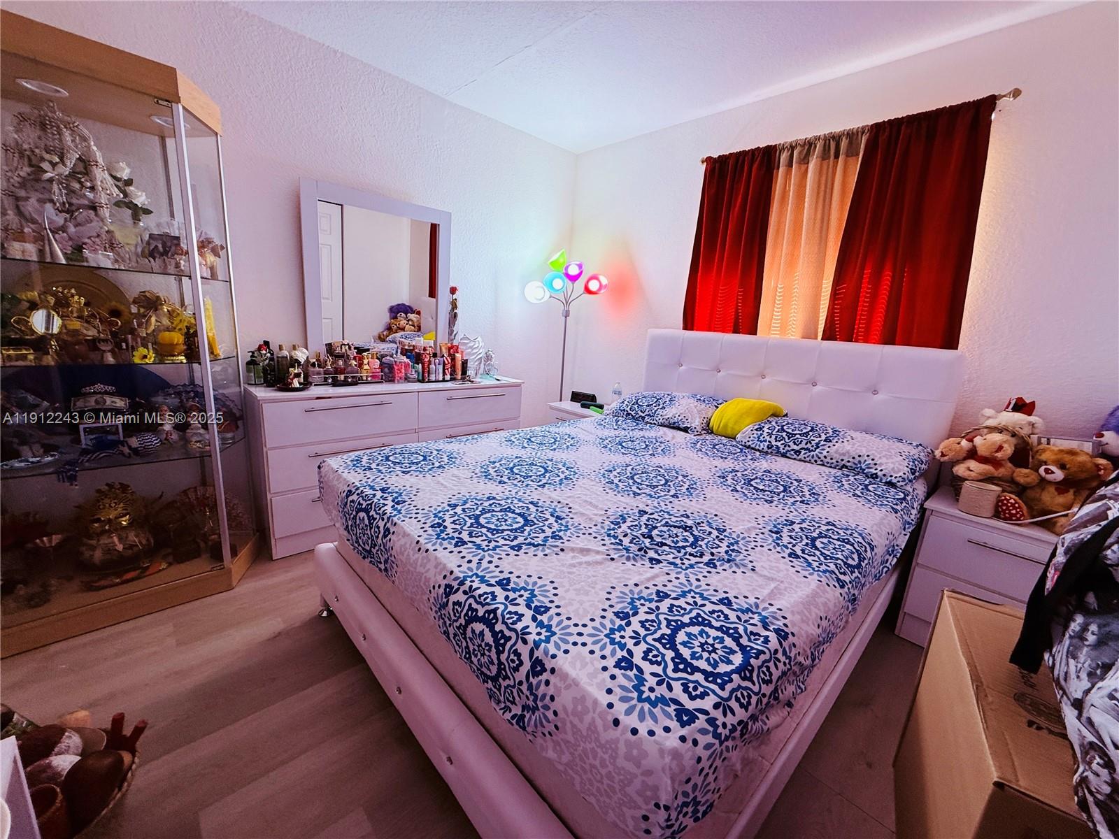 2243 Northwest 135th Terrace, Unit 2243 Opa-Locka, FL 33054 - Photo 18 of 19 a bed sitting in a bedroom next to a window