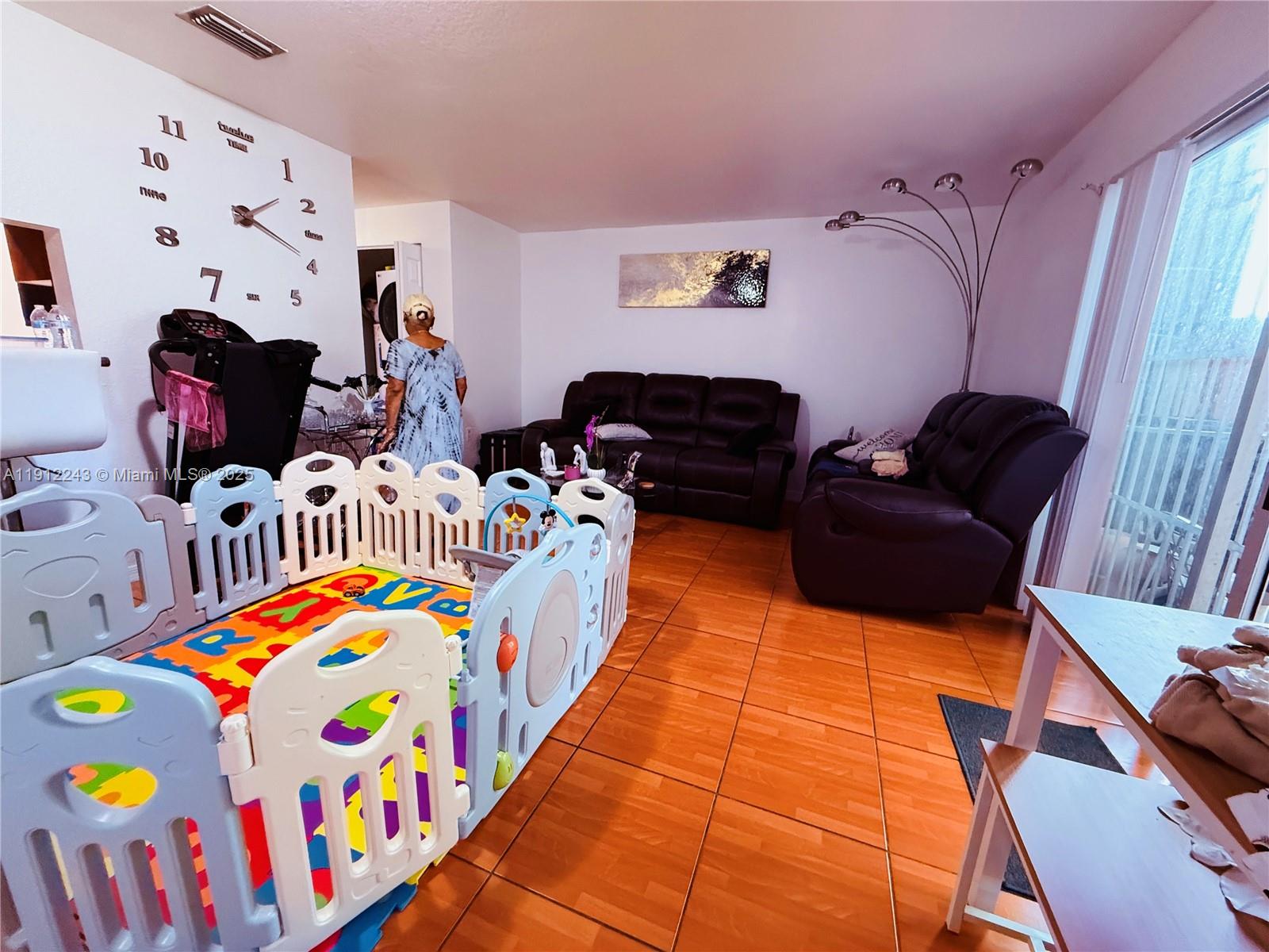 2243 Northwest 135th Terrace, Unit 2243 Opa-Locka, FL 33054 - Photo 10 of 19 a bedroom with furniture and a baby crib