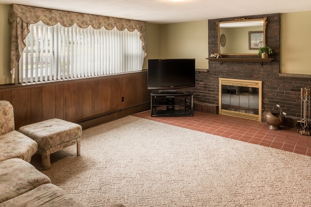 3 Surrey Lane Canton, MA 02021 - Photo 6 of 9 a living room with furniture a flat screen tv and a fireplace