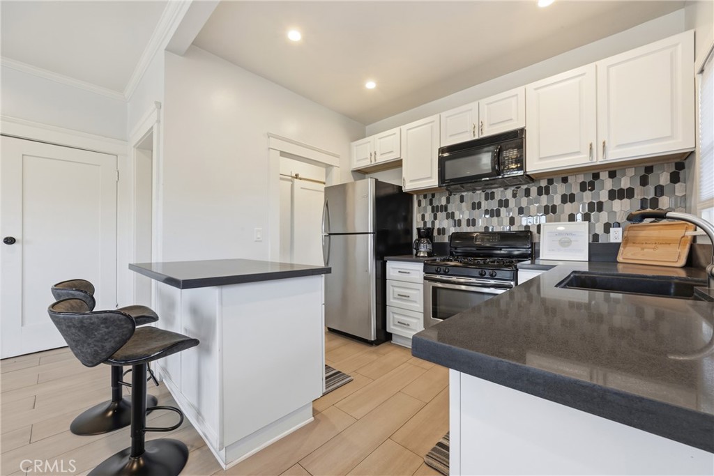 325 East 14th Street Long Beach, CA 90813 - Photo 10 of 21 a kitchen with stainless steel appliances kitchen island granite countertop a refrigerator and a sink
