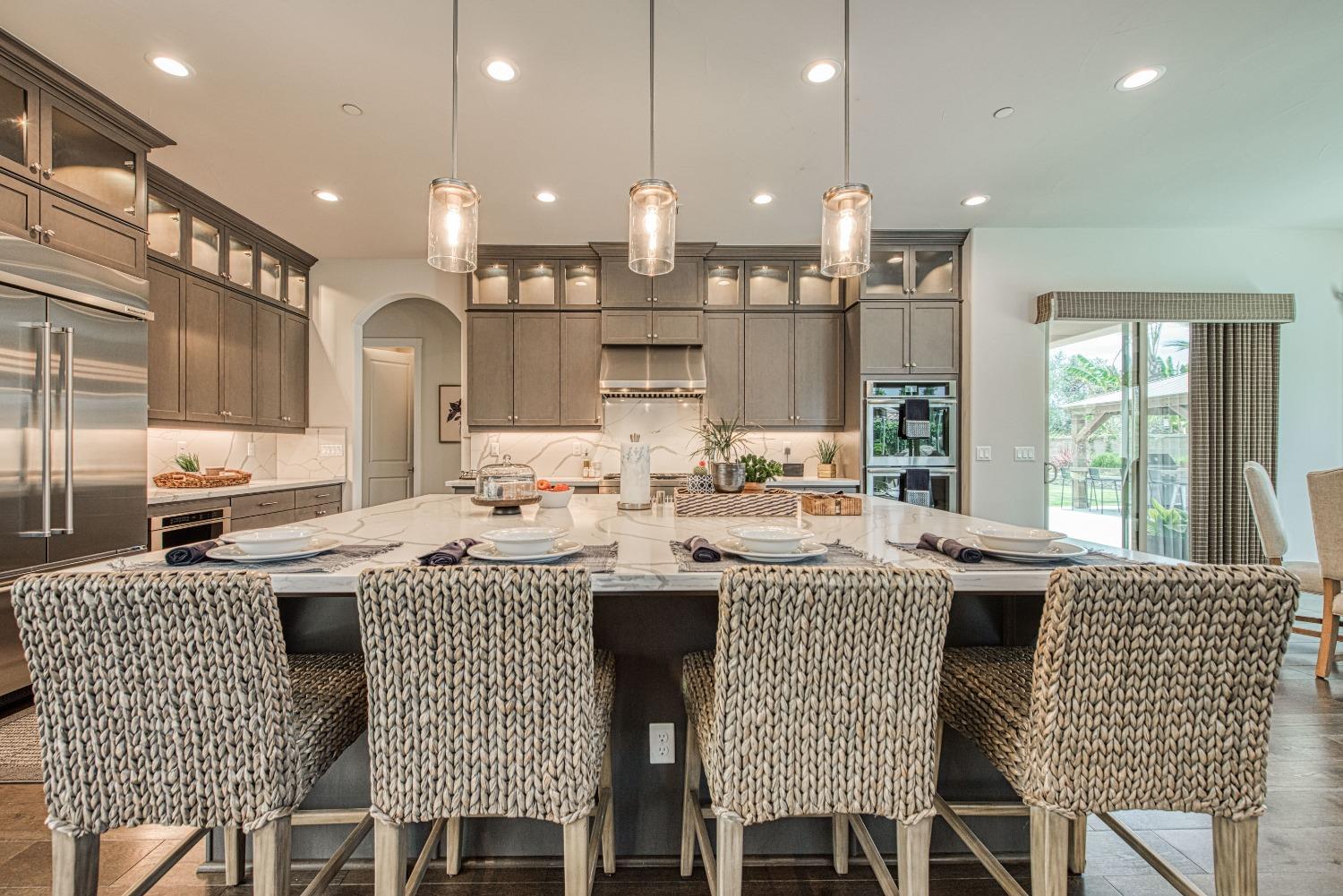 1632 North De Wolf Avenue Clovis, CA 93619 - Photo 37 of 80 a kitchen with stainless steel appliances granite countertop a kitchen island a stove a cabinets a sink and a chairs