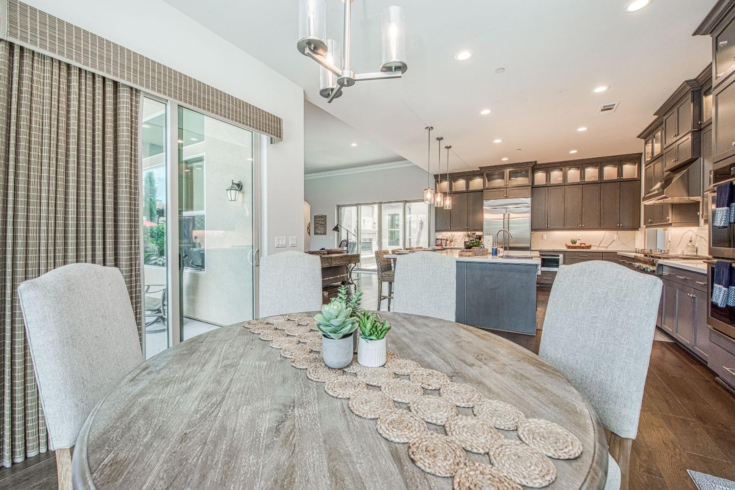 1632 North De Wolf Avenue Clovis, CA 93619 - Photo 44 of 80 a dining room with kitchen island stainless steel appliances furniture a chandelier and a view of kitchen