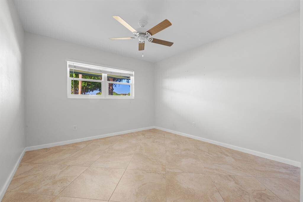 3801 Northeast 22nd Terrace, Unit 2 Lighthouse Point, FL 33064 - Photo 12 of 19 an empty room with windows and ceiling fan