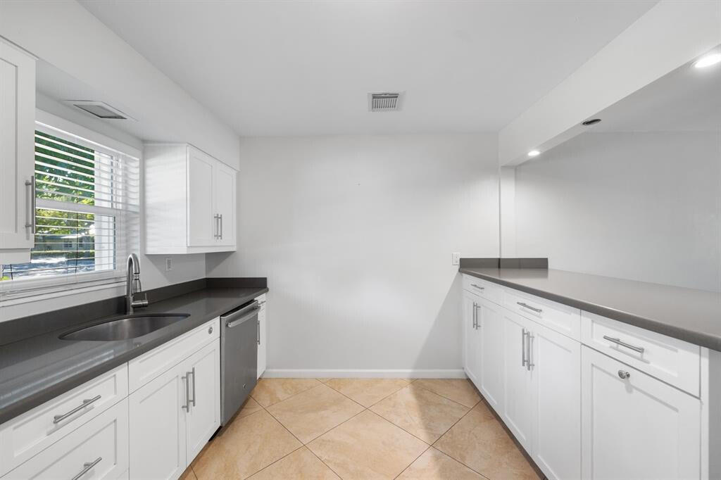 3801 Northeast 22nd Terrace, Unit 2 Lighthouse Point, FL 33064 - Photo 3 of 19 a kitchen with granite countertop white cabinets and window