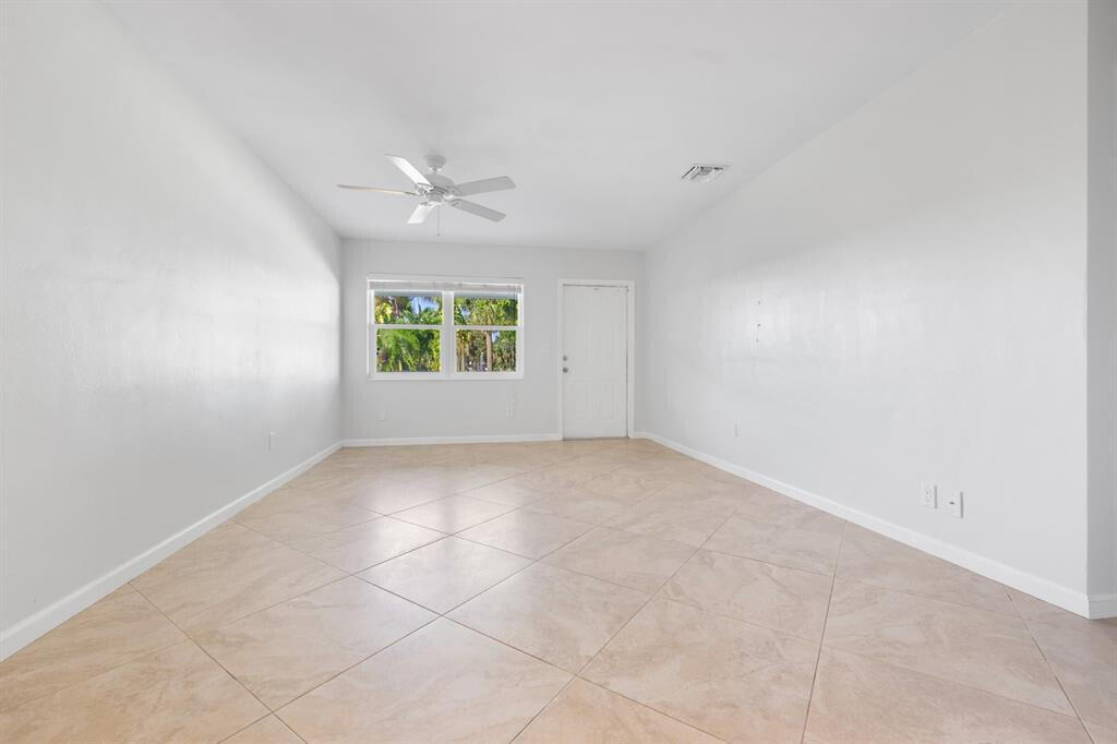 3801 Northeast 22nd Terrace, Unit 2 Lighthouse Point, FL 33064 - Photo 7 of 19 an empty room with windows and ceiling fan