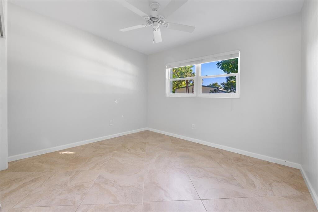 3801 Northeast 22nd Terrace, Unit 2 Lighthouse Point, FL 33064 - Photo 9 of 19 an empty room with a window and ceiling fan