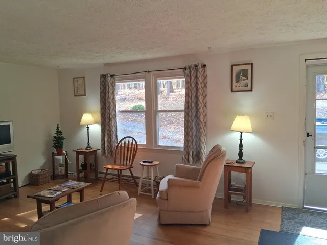 a living room with furniture a flat screen tv and a large window