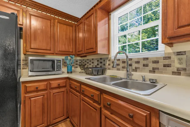 a kitchen with stainless steel appliances granite countertop a sink and a cabinets