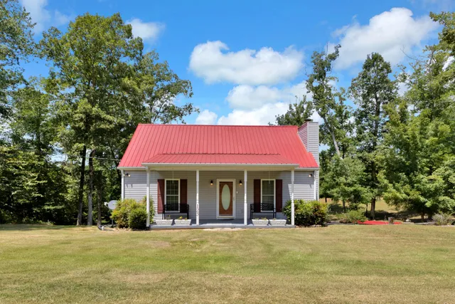 a front view of a house with a yard and trees