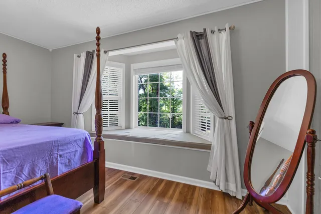 a bedroom with a bed next to a window