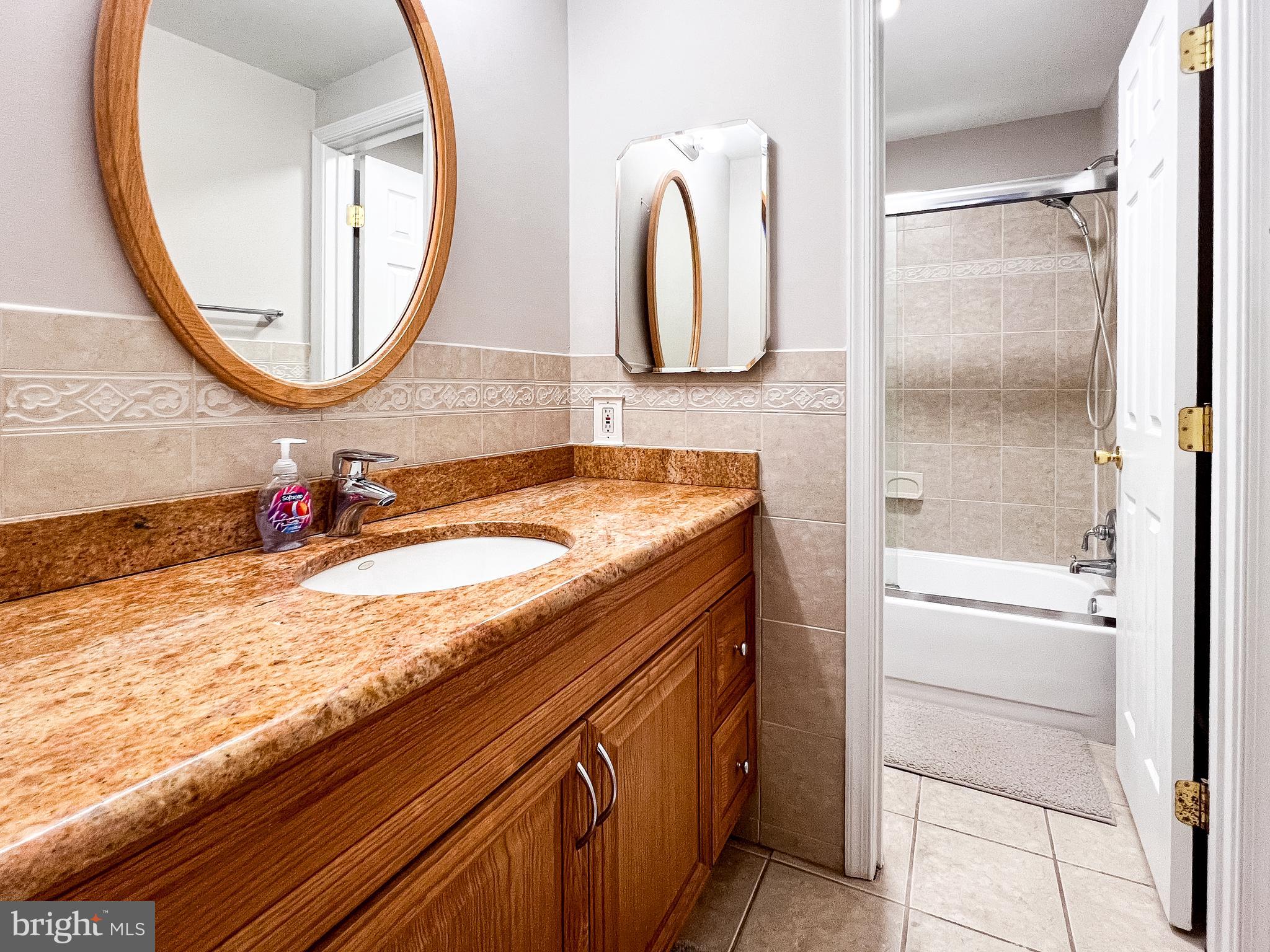 14913 Lear Lane Silver Spring, MD 20905 - Photo 22 of 34 a bathroom with a granite countertop sink and a mirror