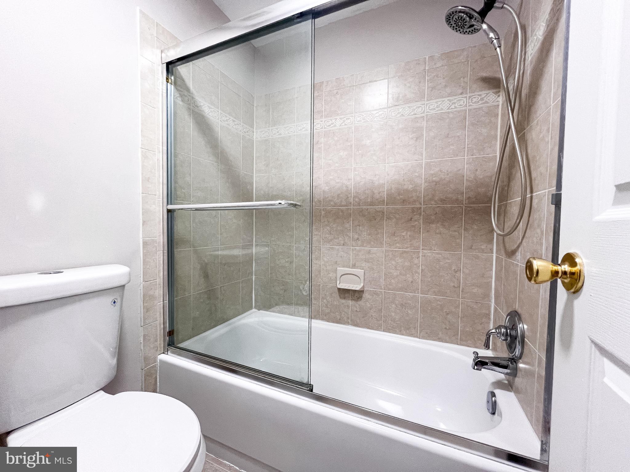 14913 Lear Lane Silver Spring, MD 20905 - Photo 23 of 34 a bathroom with a granite countertop bathtub shower and toilet