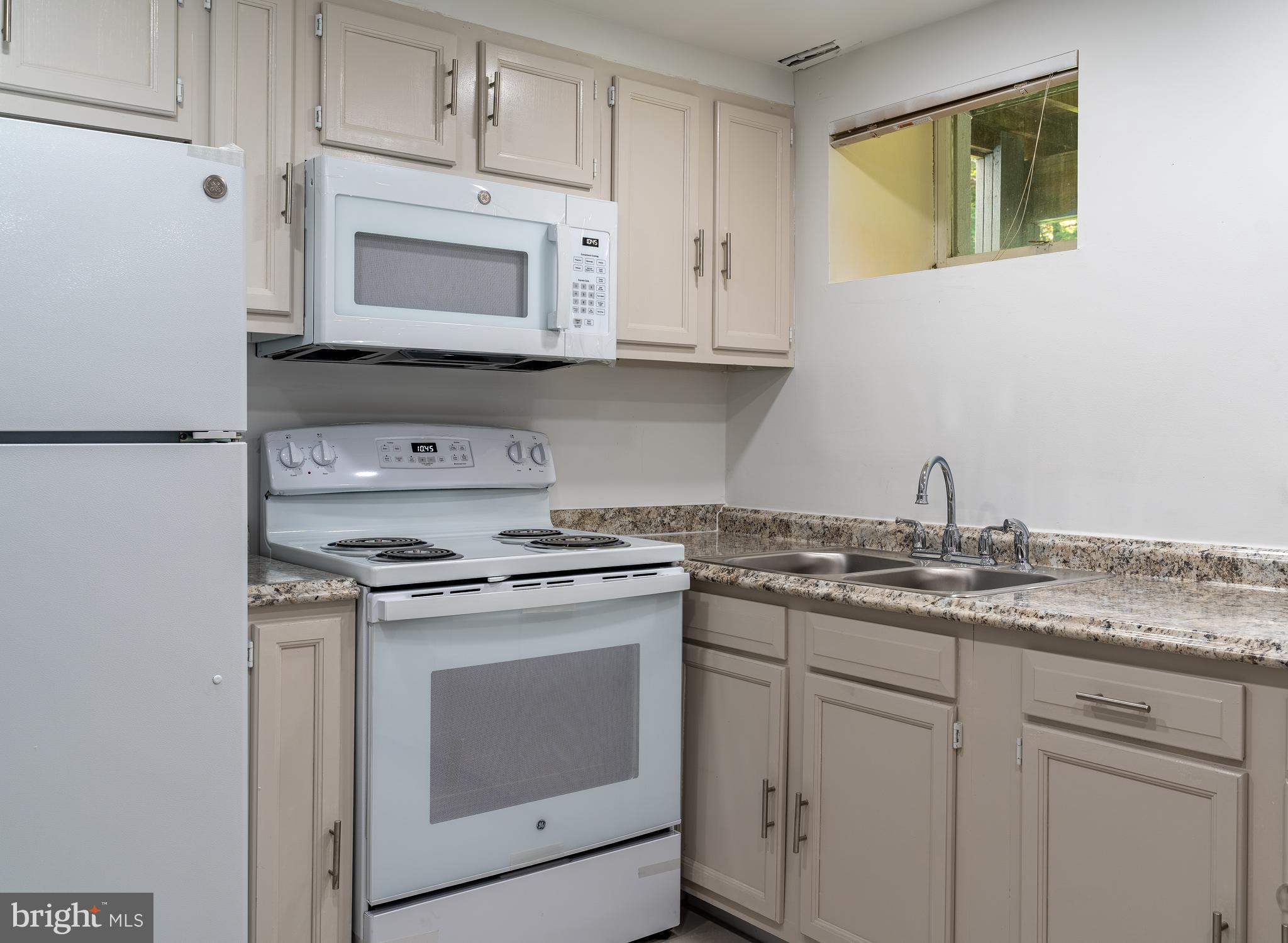14913 Lear Lane Silver Spring, MD 20905 - Photo 28 of 34 a kitchen with granite countertop white cabinets and white appliances