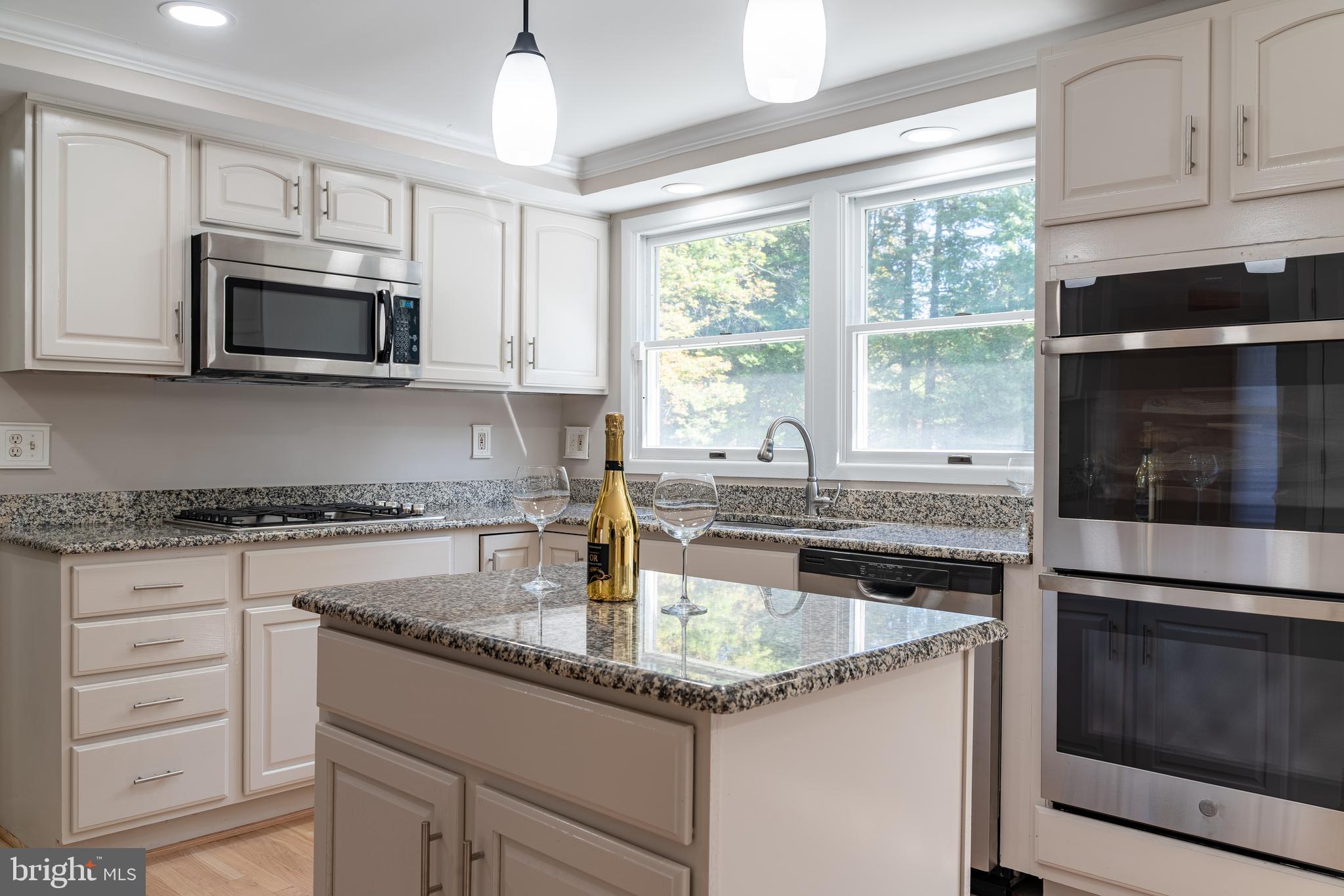 14913 Lear Lane Silver Spring, MD 20905 - Photo 6 of 34 a kitchen with granite countertop a sink stainless steel appliances and white cabinets