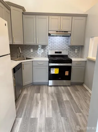 a kitchen with granite countertop a sink a stove and cabinets
