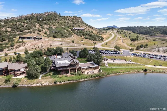 an aerial view of a house with a garden and mountains