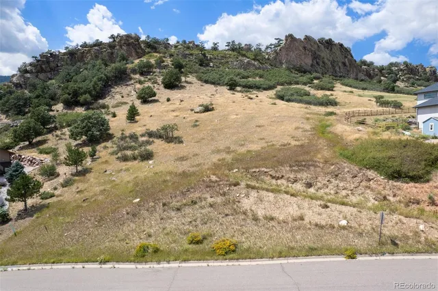 a view of a yard with wooden fence