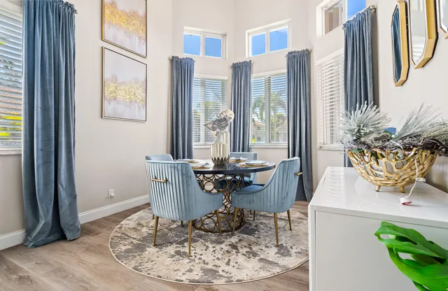 a dining room with wooden floor a glass table and chairs