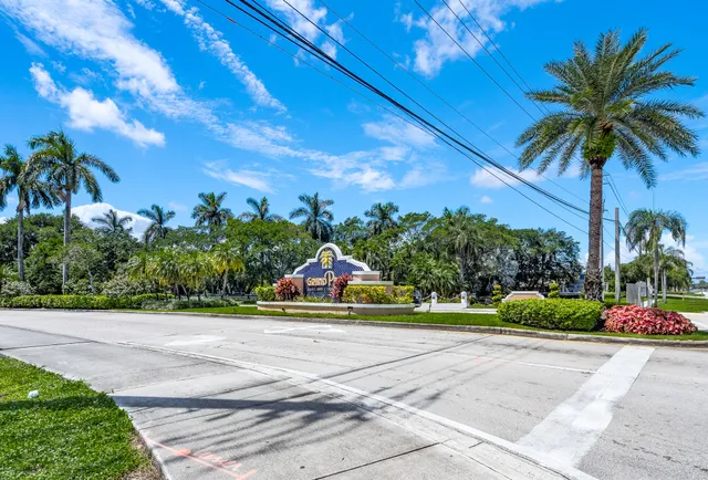 a front view of a house with a yard and palm tree