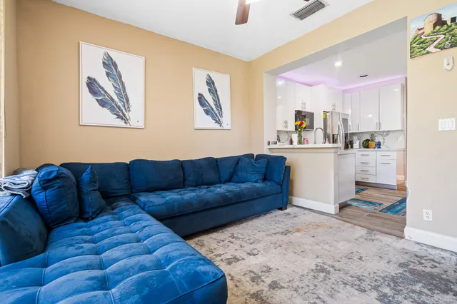 a living room with furniture and kitchen view