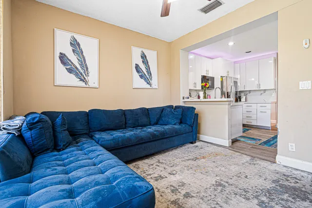 a living room with furniture and kitchen view