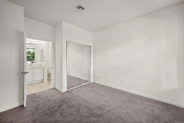 an empty room with closet and a bathroom