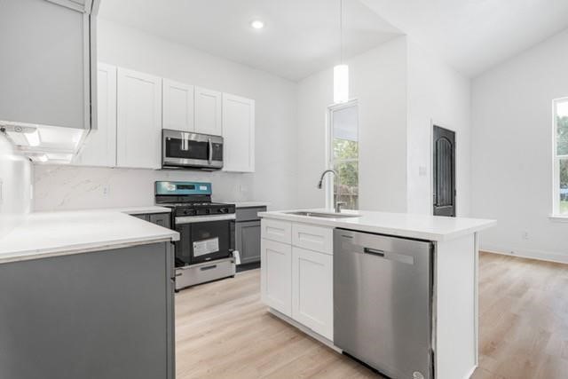5306 Ridgeway Drive, Unit A Houston, TX 77033 - Photo 4 of 14 Kitchen – Bright, functional kitchen featuring a center island with sink, stainless steel appliances, two-tone cabinetry, generous counter space, and recessed lighting.
