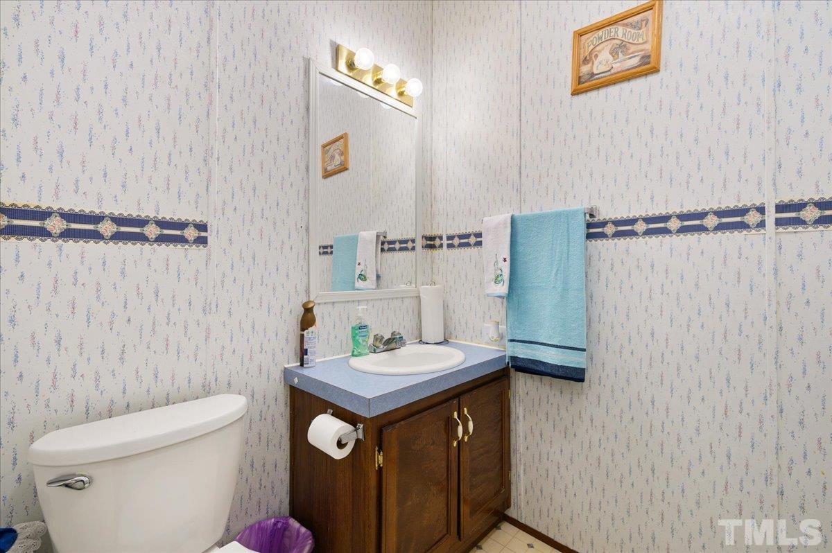 6604 Stokes Road Middlesex, NC 27557 - Photo 13 of 15 a bathroom with a toilet a sink and a shower curtain