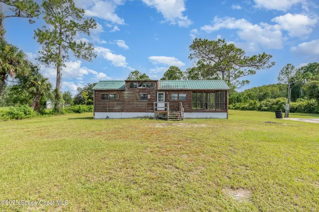 a house view with swimming pool and trees in the background