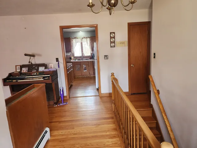 a view of a hallway with workspace and wooden floor