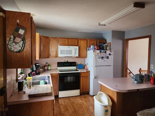 a kitchen with stainless steel appliances a stove a refrigerator a sink and a dining table