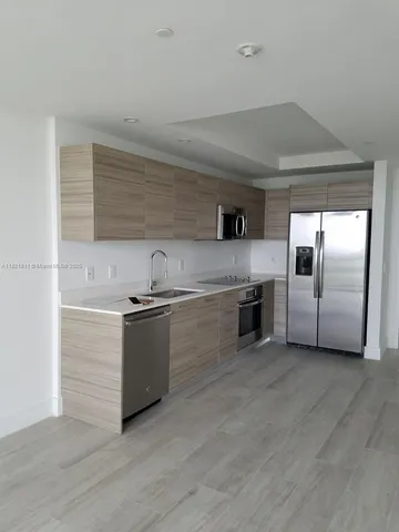 a view of a big room with wooden floor and windows