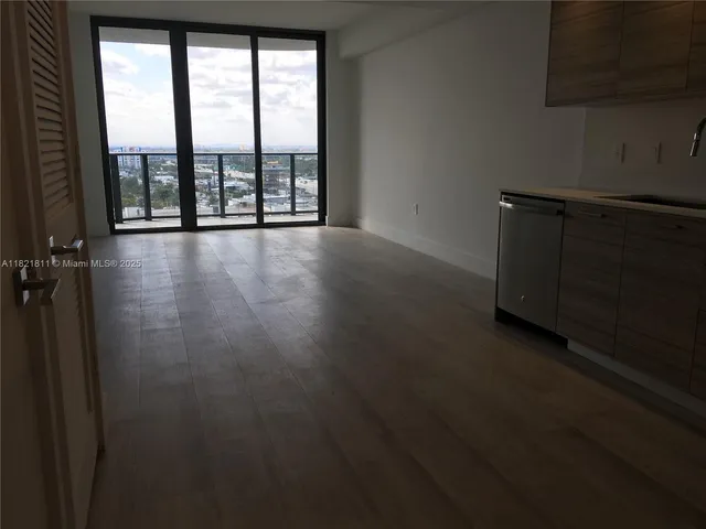 a view of a room with wooden floor and a fireplace