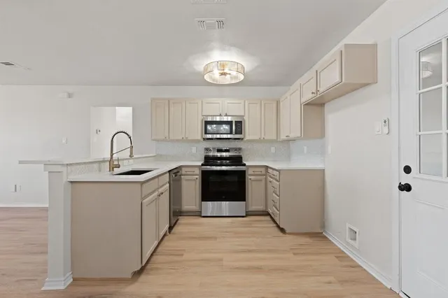 a kitchen with granite countertop a sink stove and refrigerator