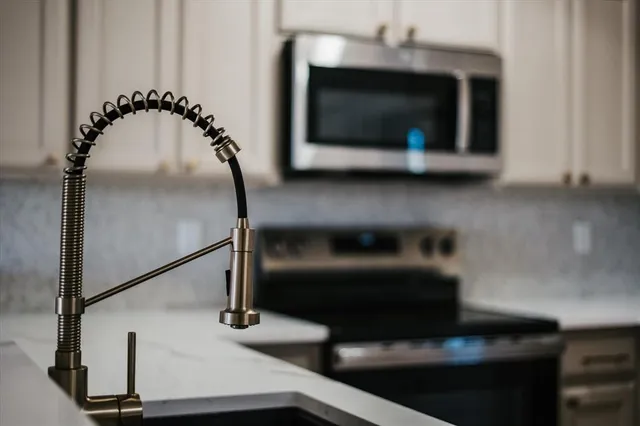 a kitchen with granite countertop a stove and a microwave