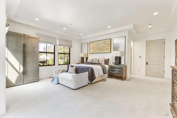 a spacious bedroom with a bed and a large window