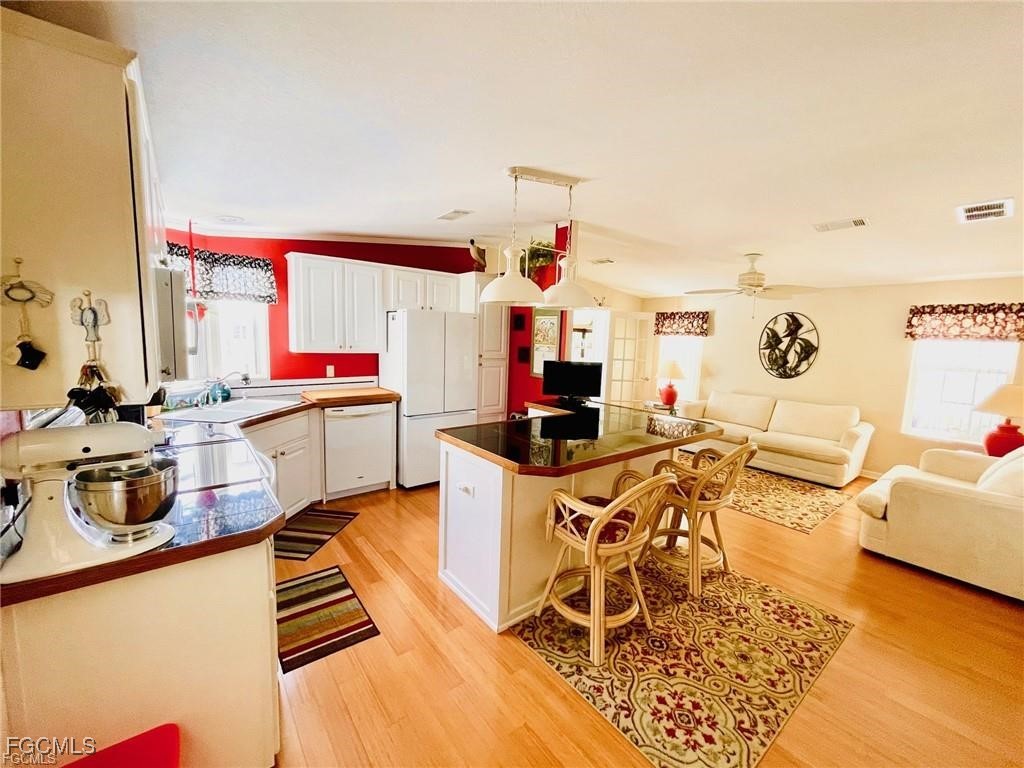 3064 Sloop Lane St. James City, FL 33956 - Photo 13 of 30 a kitchen with stainless steel appliances kitchen island granite countertop a sink and cabinets
