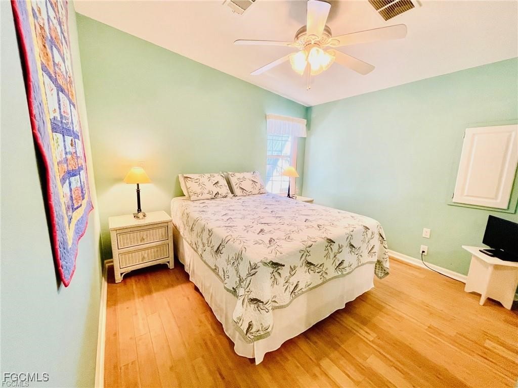 3064 Sloop Lane St. James City, FL 33956 - Photo 17 of 30 a bedroom with a bed and a chandelier