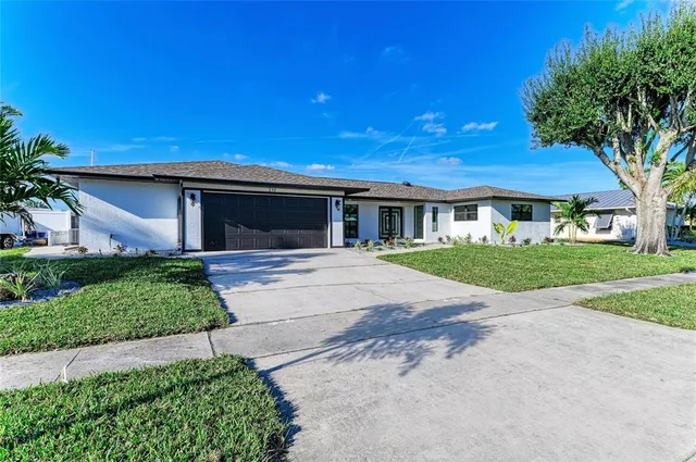 a view of an empty room with a window and a kitchen