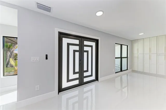 a view of an empty room with window and cabinet