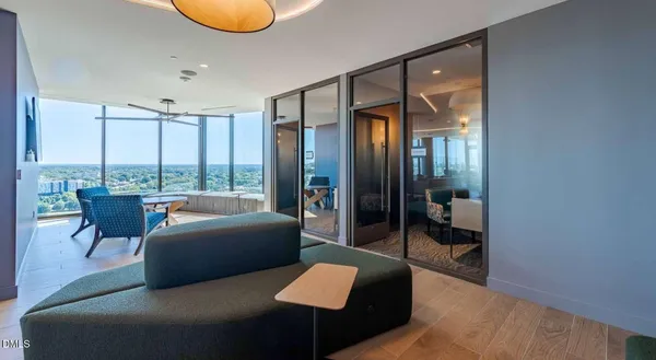 a living room with furniture wooden floor dining table and a large window