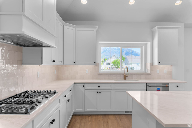 11711 South Halls Crk Road Draper, UT 84020 - Photo 17 of 31 Kitchen featuring white cabinets, stainless steel appliances, light wood-type flooring, recessed lighting, and tasteful backsplash