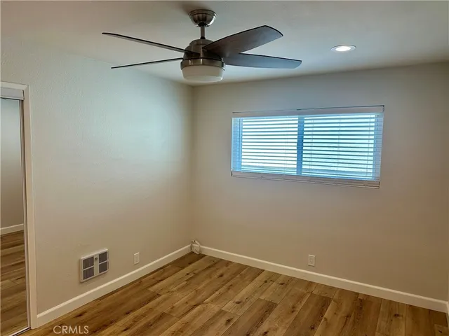 an empty room with a window and a fan