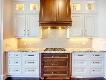 a kitchen with stainless steel appliances granite countertop a stove and a wooden floors