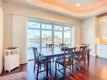 a view of a a dining room with furniture window and wooden floor