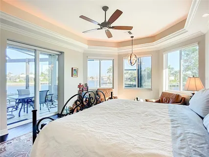 a bedroom with a bed a dresser and a chandelier