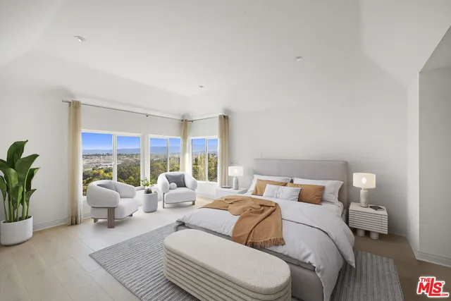 a bedroom with furniture and a large window